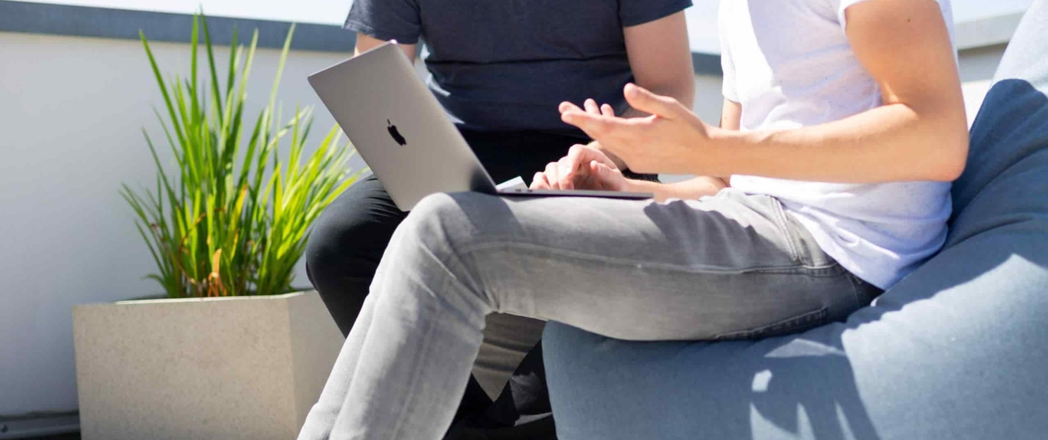 two men looking over laptop having a conversation